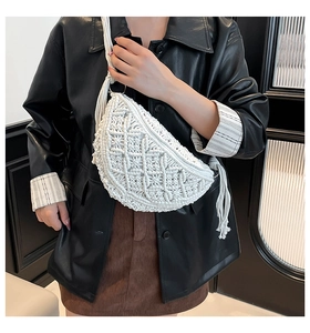 Detailed macro view of white macrame woven texture and fringe tassel on crossbody bag