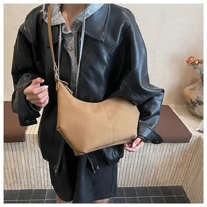 Sac bandoulière demi-lune en similicuir kaki porté par un mannequin en veste de cuir noir