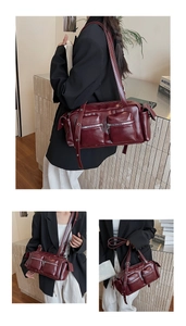 Detail view of dark red glossy leather shoulder bag with functional multi-pocket design
