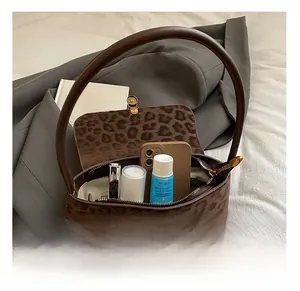 Detailed interior of leopard print shoulder bag showing space for phone and makeup