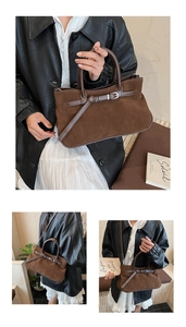 Detailed view of brown faux suede handbag showing decorative buckle and shoulder strap