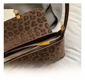 Close-up of golden zipper and hardware on vintage leopard print shoulder bag