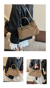 Detail of suede baguette bag showing leather buckle and adjustable shoulder strap texture