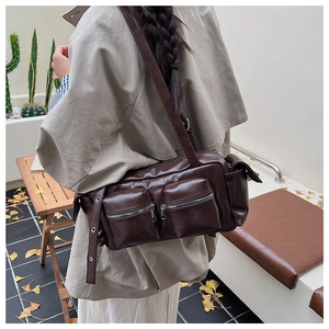 Detail of vintage brown PU leather shoulder bag with dual zipper pockets and eyelet strap