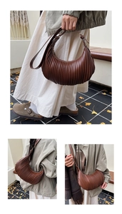 Detailed close-up of brown pleated crescent cloud bag with vertical stripe texture