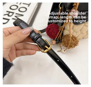 Detail of adjustable black leather strap with gold buckle on a shearling handbag