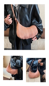 Detail of dusty pink pleated hobo bag with vertical ridges and adjustable strap