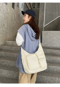 Photo street style d'un grand sac fourre-tout en toile blanc cassé à poches