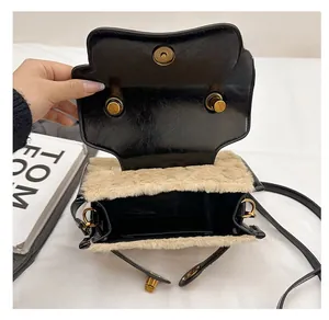 Macro view of the plush beige faux fur interior with golden magnetic closure of the handbag