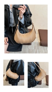 Detailed macro view of the pleated beige crescent shoulder bag with vertical stripes