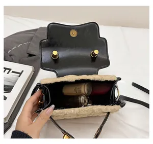 Detail shot of the plush crossbody bag interior holding cosmetics and gold chain