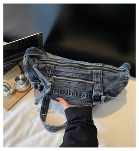Detail view of washed denim crossbody bag featuring Fashion embroidery on a desk