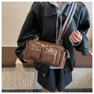 Detail of dark brown vintage faux leather shoulder bag with two front zipper pockets