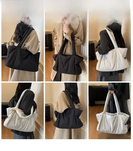 Detail view of large quilted puffer tote bags with drawstring accents in black and beige