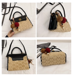 Detail view of lamb wool crossbody bag with heart pattern and plush pompom charm