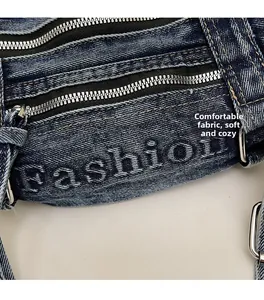 Detailed macro view of washed denim tote with dual silver zippers and fashion print