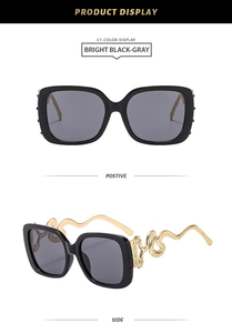 Detail of black square oversized sunglasses with gold metal snake-shaped temple design