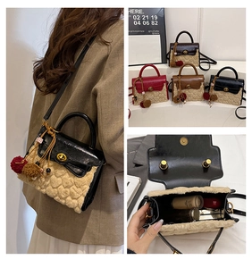 Detail view of heart-embossed plush crossbody bag with metal lock and plush ball charm
