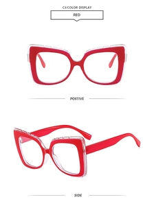 Detail view of red cat-eye oversized glasses with unique red-white layered frame design