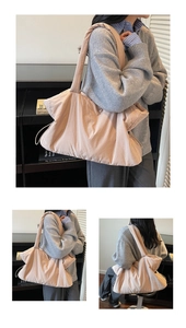 Detail showing the quilted nylon texture and side drawstring of this beige tote bag