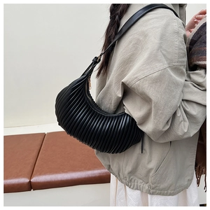 Macro shot showing pleated texture and sleek silhouette of a black crescent shoulder bag