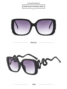 Detail of metal snake shaped temples and purple gradient lenses on oversized sunglasses