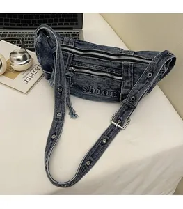 Detail showing vintage denim messenger bag with metal zippers and adjustable eyelet strap