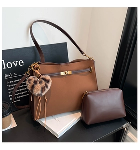 Detail of vintage brown tote bag set with heart charm and matching storage pouch