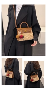 Detail view of heart-textured plush panel and golden twist lock on a faux leather handbag