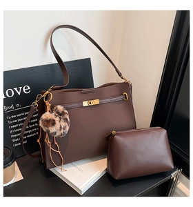 Detail of dark brown leather tote bag set with gold lock and leopard print charm