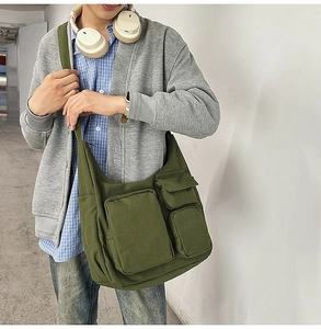 Détail du sac bandoulière en toile vert armée avec design multi-poches et sangle