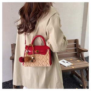 Detail of red faux leather flap and beige heart-textured shearling on the crossbody bag