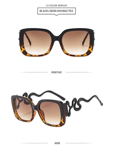 Detail of oversized square sunglasses featuring unique snake-shaped temples and gradient lenses