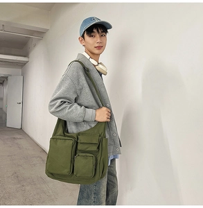 Détails du sac bandoulière en toile vert armée avec plusieurs poches pour les trajets quotidiens