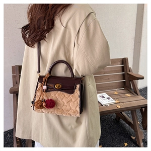 Detail of plush lamb wool kelly bag with embossed heart patterns and leather handle
