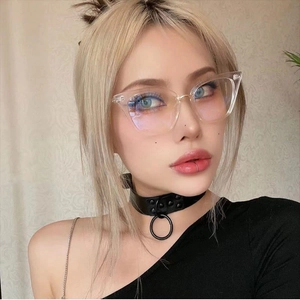 Detail of transparent cat-eye sunglasses with gold metal bridge on model wearing choker