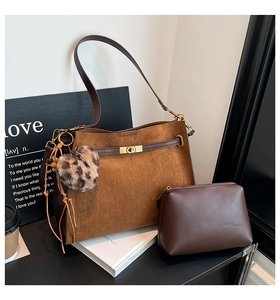Detail view of caramel faux suede tote with inner leather pouch and leopard heart charm