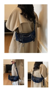 Detail of blue denim crescent bag with fashion embossing and silver zippers