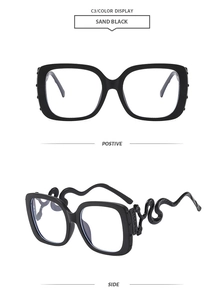 Detail of square oversized glasses with unique matte black metal snake-shaped temples