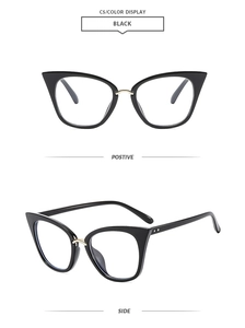 Close-up of black cat-eye sunglasses with gold metal bridge and blue light lenses