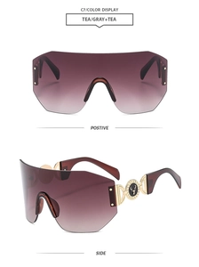Vue détaillée des lunettes de soleil sans monture avec ornements dorés et logo cerf