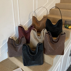 Detailed close-up showing various colors of suede tote bags with leopard embossed texture