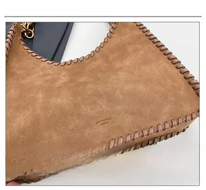 Macro detail of brown suede tote with artisanal hand-woven large stitch edge design