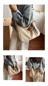Detail view of large minimalist hobo bag with plush bear charm and striped fabric strap