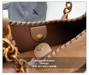 Close-up of brown woven leather bag featuring a gold magnetic snap and metal chain strap