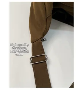 Detail of quality hardware and durable silver metal buckle on a brown canvas bag