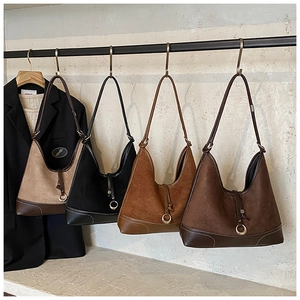 Detailed row of four hobo bags in suede and smooth leather finishes on hangers