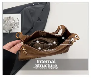 Detailed interior of dark brown suede shoulder bag showing pockets and magnetic closure