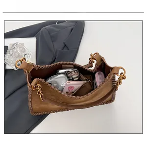 Spacious interior of retro brown suede shoulder bag with chic chunky gold chain strap