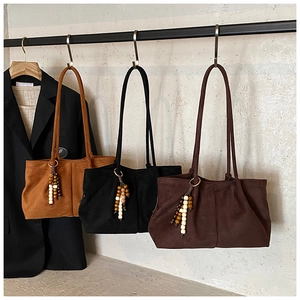 Trois sacs cabas en daim marron et noir avec pendentifs perlés et détails de design plissé